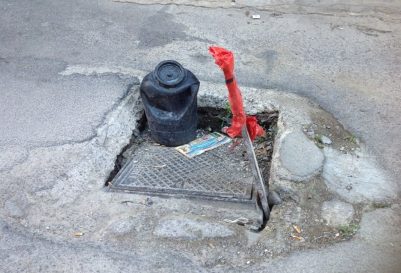 Due tombini semi sprofondati, bisogna intervenire